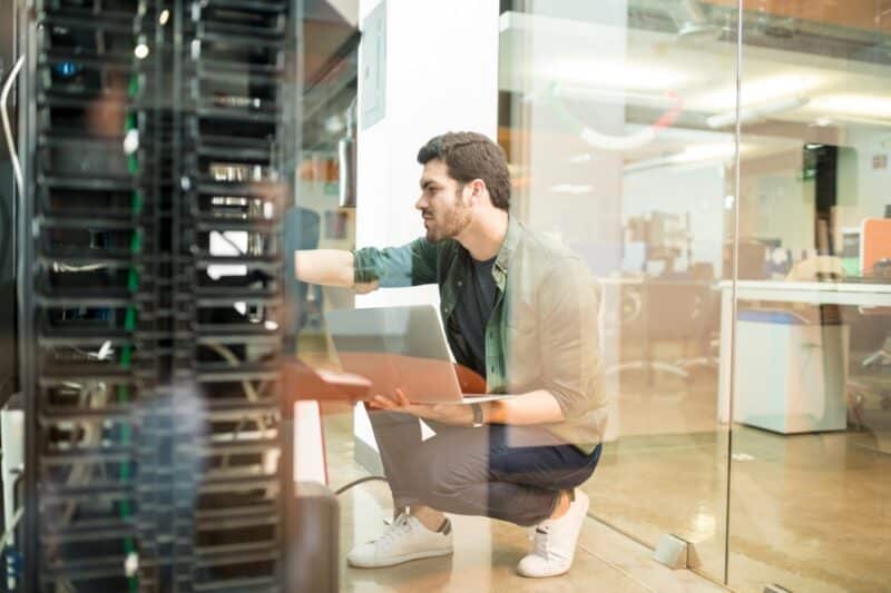 Man met laptop onderzoekt een lokale server met Windows Server 2016